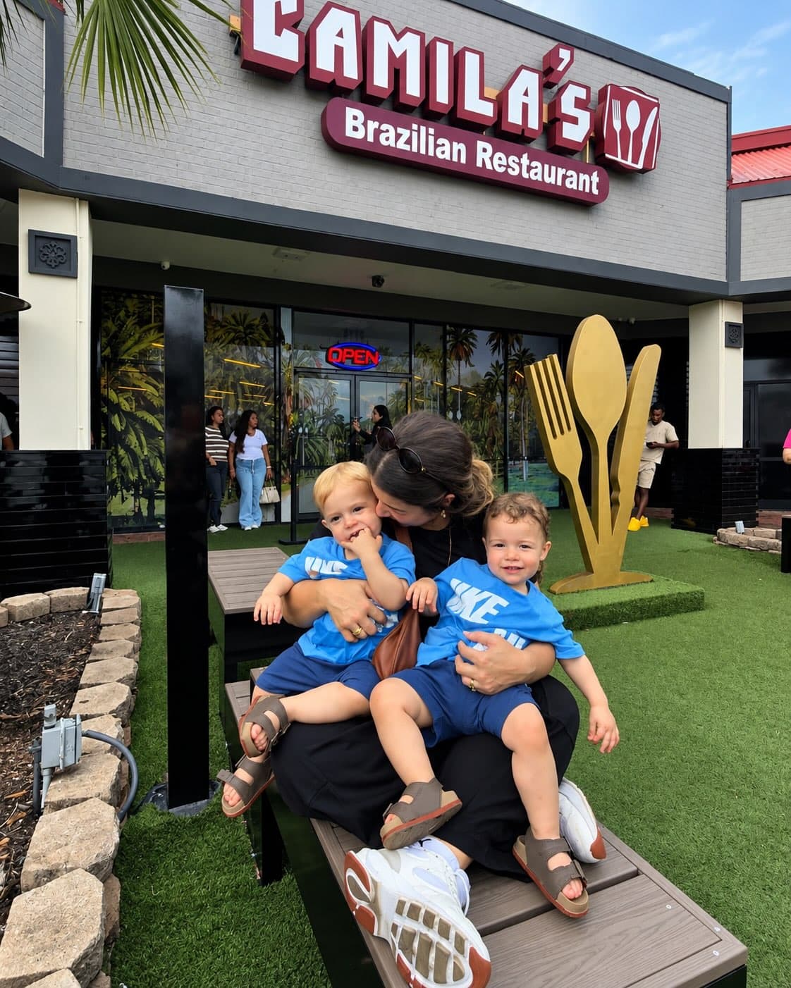 Pai com dois filhos pequenos no banco do pátio